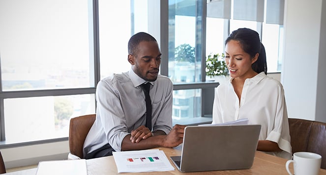 Businesspeople Working On Laptop In Boardroom Together