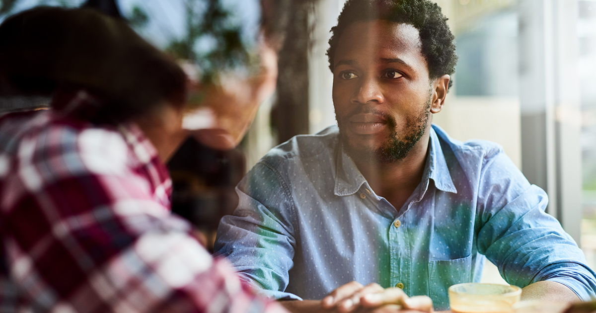 Shot of an affectionate young couple having a discussion about something on their date at a coffee shop