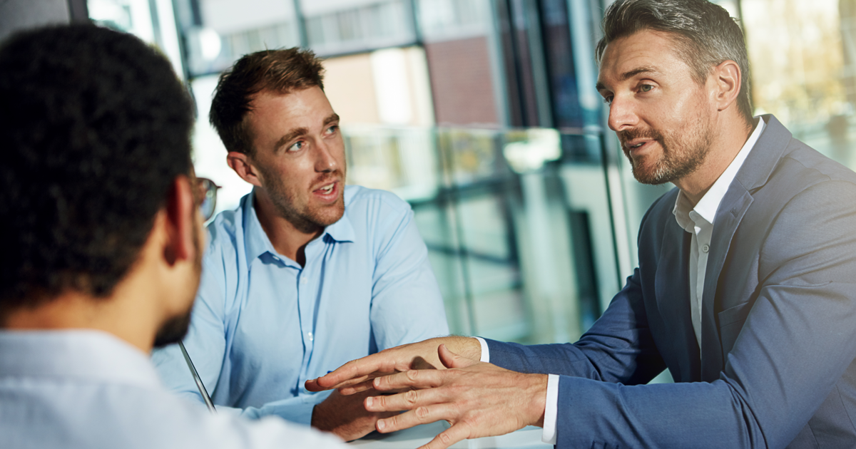 Group of men sitting at table talking