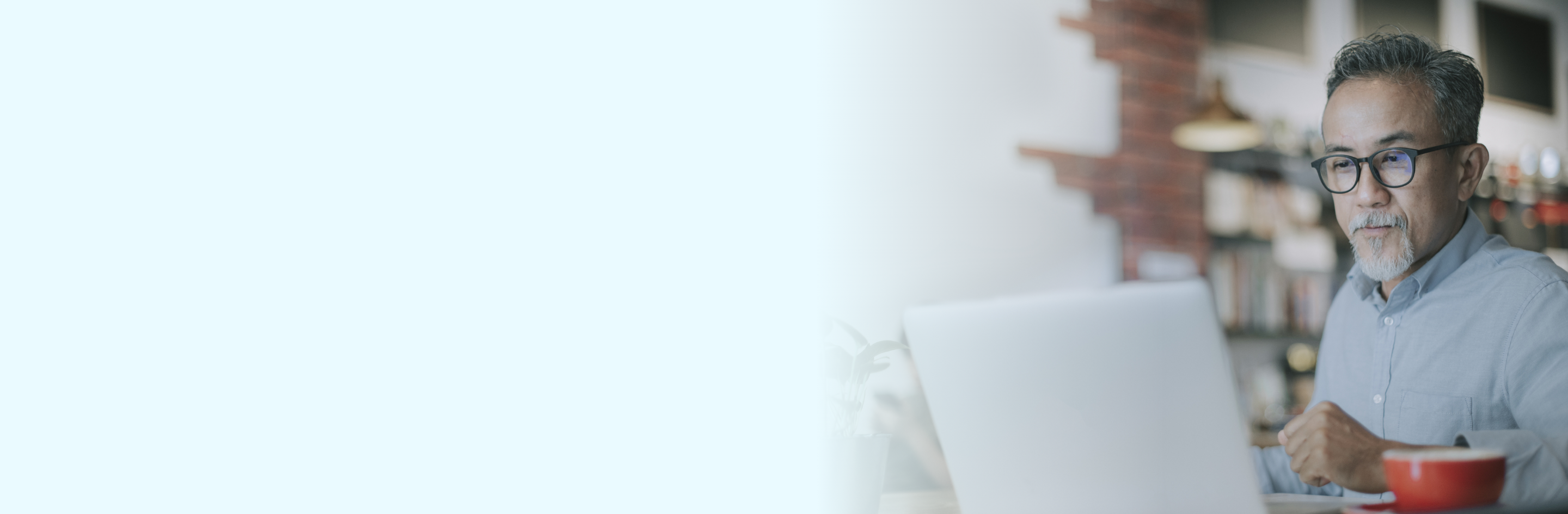 asian american man on laptop in coffee shop